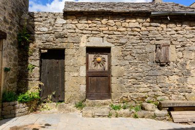 Bu manzara fotoğrafı Avrupa 'da, Fransa' da, Occitania 'da, Aveyron' da, La Couvertoirade 'da, yazın çekildi. Ortaçağ köyünün sokaklarını görüyoruz, güneşin altında..