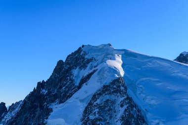 Bu manzara fotoğrafı Avrupa 'da, Fransa' da, Rhone Alpes 'te, Savoie' de, Alpler 'de, kışın çekildi. Mont Blanc 'ın dağlarında güneşin altında bir zirve görüyoruz..