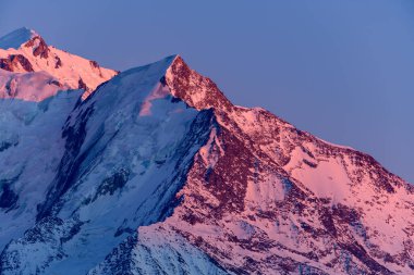 Bu manzara fotoğrafı Avrupa 'da, Fransa' da, Rhone Alpes 'te, Savoie' de, Alpler 'de, kışın çekildi. Aiguille de Bionnassay 'i pembe renkte, güneşin altında görüyoruz..