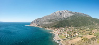 Bu manzara fotoğrafı Avrupa 'da, Yunanistan' da, Aetolia Acarnania 'da, Kato Vasiliki' de yaz aylarında İyon Denizi tarafından Patras 'a doğru çekildi. Kayalık sahilde yeşil kırsalın ortasında, güneşin altında şehri görüyoruz..