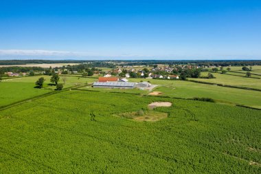 Bu manzara fotoğrafı Avrupa 'da, Fransa' da, Burgundy 'de, Nievre' de, Saint-Germain-Chassenay 'de, Nevers yakınlarında, yazın çekildi. Kırsalın ortasında, güneşin altında geleneksel bir köy görüyoruz..