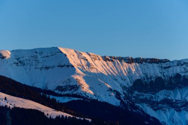 Bu manzara fotoğrafı Avrupa 'da, Fransa' da, Rhone Alpes 'te, Savoie' de, Alpler 'de, kışın çekildi. Mont Blanc kalabalığını Mont Joly ve Aiguille Croche arasında gün batımında, güneşin altında görüyoruz..