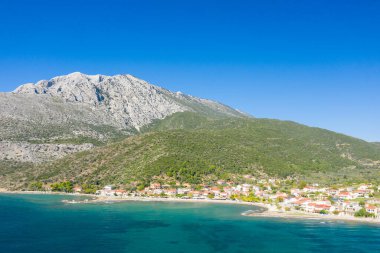 Bu manzara fotoğrafı Avrupa 'da, Yunanistan' da, Aetolia Acarnania 'da, Kato Vasiliki' de yaz aylarında İyon Denizi tarafından Patras 'a doğru çekildi. Kayalık sahilde kumsalı görüyoruz. Yeşil kırsalın ortasında, güneşin altında..