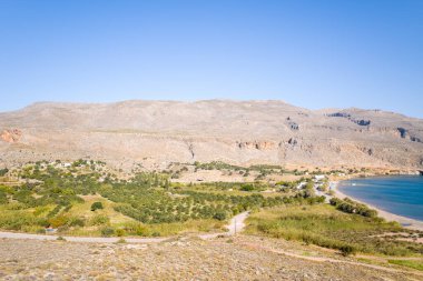 Bu manzara fotoğrafı Avrupa 'da, Yunanistan' da, Girit 'te, Kato Zakros' ta, Akdeniz kıyısında, yazın çekildi. Kurak dağların eteğinde, güneşin altında güzel kumlu bir sahil görüyoruz..