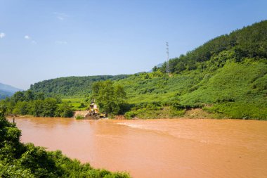 Bu manzara fotoğrafı Asya 'da Vietnam' da, Tonkin 'de Dien Bien Phu ve Lai Chau arasında çekilmiştir. Yeşil dağların ortasında, güneşin altında Kızıl Nehir 'i görüyoruz..