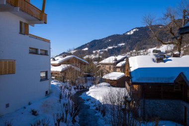 Bu manzara fotoğrafı Avrupa 'da, Fransa' da, Rhone Alpes 'te, Savoie' de, Alpler 'de, kışın çekildi. Dağların ortasında, güneşin altında Megeve şehrinin Chalets 'ini görüyoruz..