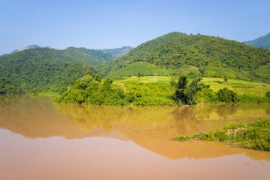 Bu manzara fotoğrafı Asya 'da Vietnam' da, Tonkin 'de Dien Bien Phu ve Lai Chau arasında çekilmiştir. Yeşil dağların ortasında, güneşin altında Kızıl Nehir 'i görüyoruz..
