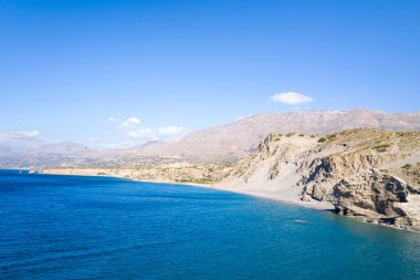 Bu manzara fotoğrafı Avrupa 'da, Yunanistan' da, Girit 'te, Agios Pavlos' ta, Akdeniz kıyısında, yazın çekildi. Güneşin altındaki kayalık sahili ve kurak uçurumları görüyoruz..