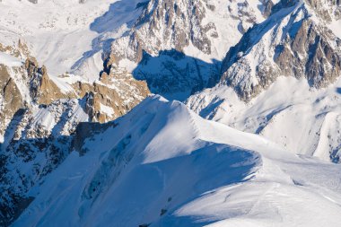 Bu manzara fotoğrafı Avrupa 'da, Fransa' da, Rhone Alpes 'te, Savoie' de, Alpler 'de, kışın çekildi. Güneşin altında kar kaplı Mont Blanc kalabalığının dağlarını görüyoruz..