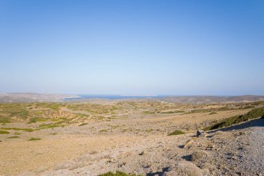 Bu manzara fotoğrafı Avrupa 'da, Yunanistan' da, Girit 'te, Sitia' ya doğru, Akdeniz 'in kıyısında, yazın çekildi. Dağların ortasında, güneşin altında kurak kırları görüyoruz..