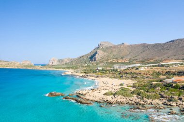 Bu manzara fotoğrafı Avrupa 'da, Yunanistan' da, Girit 'te Kissamos' a doğru, Chania 'ya doğru, Akdeniz' in kıyısında, yazın çekildi. Kurak kırlarda, güneşin altında kayalık kayalıkların eteğindeki kumlu sahili görüyoruz..