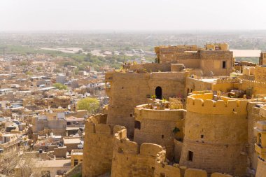 Bu manzara fotoğrafı Asya, Hindistan, Rajasthan, Jaisalmer, Summer 'da çekildi. Jaisalmer Kalesi 'nin surlarını görüyoruz, güneşin altında..