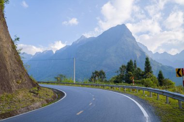 Bu manzara fotoğrafı Asya 'da Vietnam' da, Tonkin 'de Lai Chau ve Sapa arasında yazın çekildi. Kırsal ve dağların ortasında asfalt bir yol görüyoruz. Güneşin altında..