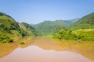 Bu manzara fotoğrafı Asya 'da Vietnam' da, Tonkin 'de Dien Bien Phu ve Lai Chau arasında çekilmiştir. Yeşil dağların ortasında, güneşin altında Kızıl Nehir 'i görüyoruz..
