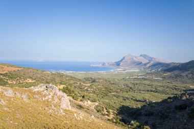 Bu manzara fotoğrafı Avrupa 'da, Yunanistan' da, Girit 'te Kissamos' a doğru, Chania 'ya doğru, Akdeniz' in kıyısında, yazın çekildi. Kırsalda, güneşin altında seraların ve zeytin ağaçlarının kıyısındaki kumsalı görüyoruz..