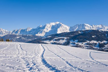 Bu manzara fotoğrafı Avrupa 'da, Fransa' da, Rhone Alpes 'te, Savoie' de, Alpler 'de, kışın çekildi. Mont Blanc kalabalığında güneşin altındaki patikaları görüyoruz..