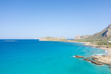 Bu manzara fotoğrafı Avrupa 'da, Yunanistan' da, Girit 'te Kissamos' a doğru, Chania 'ya doğru, Akdeniz' in kıyısında, yazın çekildi. Kurak kırlarda, güneşin altında kayalık kayalıkların eteğindeki kumlu sahili görüyoruz..