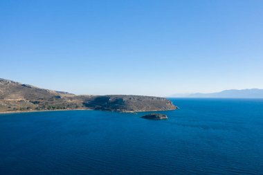 Bu manzara fotoğrafı Avrupa 'da, Yunanistan' da, Peloponnese 'de, Argolis' te, Nafplio 'da, Myrto sahilinde, yazın çekildi. Kurak kayalık sahili ve yeşil kırsalını görüyoruz. Güneşin altında, küçük plajların kenarında..