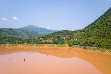 Bu manzara fotoğrafı Asya 'da Vietnam' da, Tonkin 'de Dien Bien Phu ve Lai Chau arasında çekilmiştir. Yeşil dağların ortasında, güneşin altında Kızıl Nehir 'i görüyoruz..