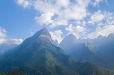 Bu manzara fotoğrafı Asya 'da, Vietnam' da, Tonkin 'de, Sapa' da, yazın çekildi. Fan Si Pan topluluğunu ve onun yeşil dağlarını görüyoruz, güneşin altında.