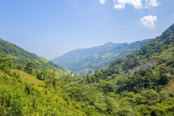 This landscape photo was taken, in Asia, in Vietnam, in Tonkin, between Dien Bien Phu and Lai Chau, in summer. We see tropical forests in the mist, under the Sun.