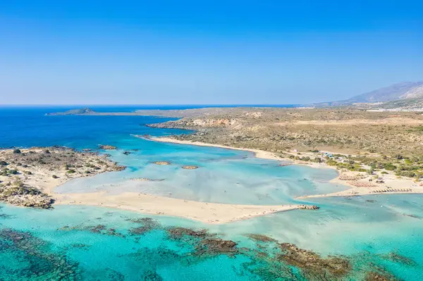 This landscape photo was taken, in Europe, in Greece, in Crete, in Elafonisi, By the Mediterranean sea, in summer. You can see the fine sandy beach and its heavenly colored water, under the sun.