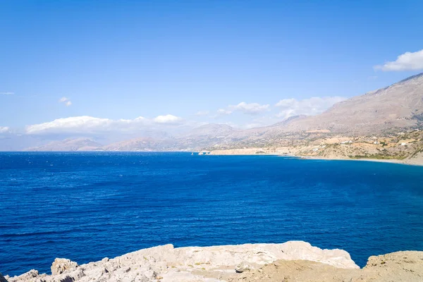 This landscape photo was taken, in Europe, in Greece, in Crete, in Agios Pavlos, By the Mediterranean sea, in summer. We see the rocky coast and its arid cliffs, under the sun.