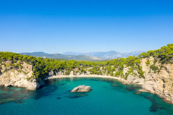 Bu manzara fotoğrafı Avrupa 'da, Yunanistan' da, Epirus 'ta, İyon Denizi kıyısındaki İgoumenitsa' ya doğru çekildi. Alonaki Fanariou 'nun kumlu kumlu kumsalını ve güneşin altındaki yeşil kayalık kayalıklarını görüyoruz..