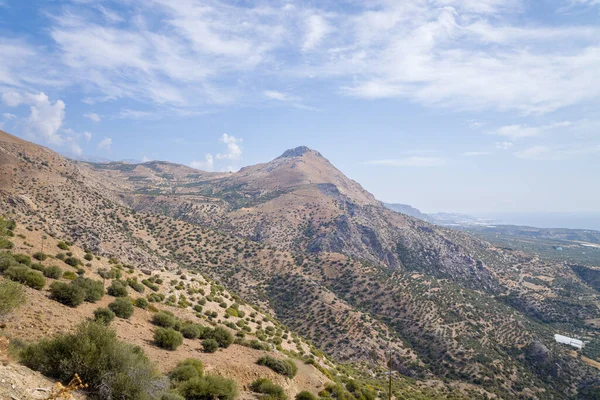 Bu manzara fotoğrafı Avrupa 'da, Yunanistan' da, Girit 'te, Akdeniz kıyısında, yazın çekildi. Kırsalda, güneşin altında kayalık ve kurak dağlar görüyoruz..