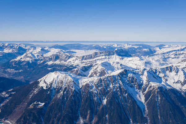 Это пейзажное фото было сделано в Европе, во Франции, Рона Альпы, в Савойе, в Альпах, зимой. Под солнцем виднеются Уйетт-де-Уш и Женевское озеро.