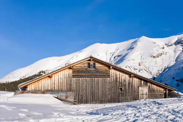 Bu manzara fotoğrafı Avrupa 'da, Fransa' da, Rhone Alpes 'te, Savoie' de, Alpler 'de, kışın çekildi. Mont Blanc 'ta Mont Joly ve Aiguille Croche arasında güneşin altında bir dağ evi görüyoruz..