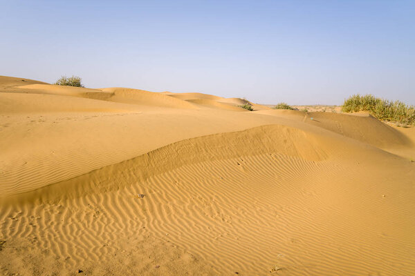 This landscape photo was taken in Asia, India, Rajasthan, Jaisalmer, Summer. We see The desert, under the Sun.