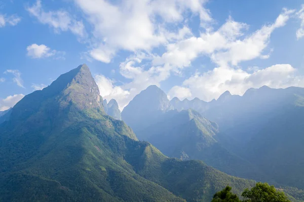 Bu manzara fotoğrafı Asya 'da, Vietnam' da, Tonkin 'de, Sapa' da, yazın çekildi. Fan Si Pan topluluğunu ve onun yeşil dağlarını görüyoruz, güneşin altında.