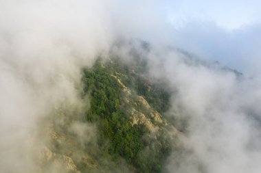 Bu manzara fotoğrafı Avrupa 'da, Fransa' da, Pireneler 'de, yazın çekildi. Bulutların altında, güneşin altında yeşil kırları görüyoruz..