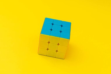 Sarı arkaplanda parlak rubik küpü, renkli fotoğraf