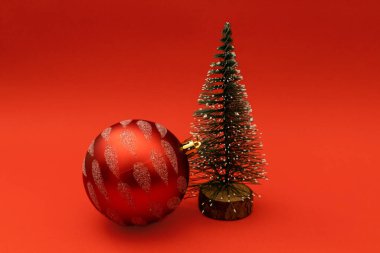 Kırmızı tatil arka planında küçük bir Noel ağacı