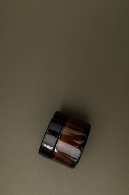 Karanlık bir arka planda kavanozlar ve kozmetik şişeleri, güzellik endüstrisinin minimalizmi.