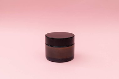 Pembe arka planda bir kavanoz krema.