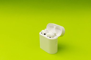 Küçük bir kutuda beyaz kulaklıklar, akıllı aygıt