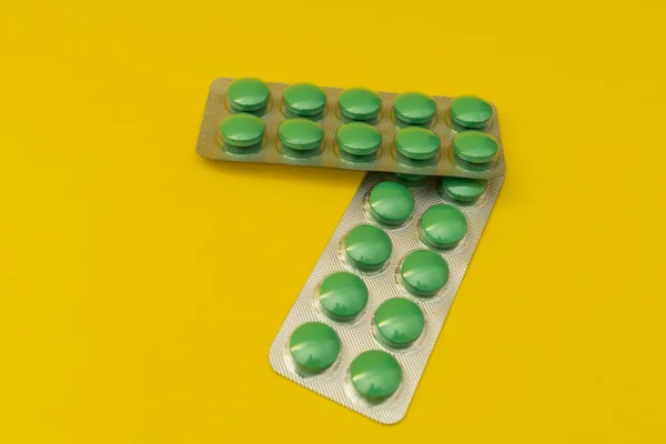 Pílulas Verdes Fundo Amarelo — Fotografia de Stock