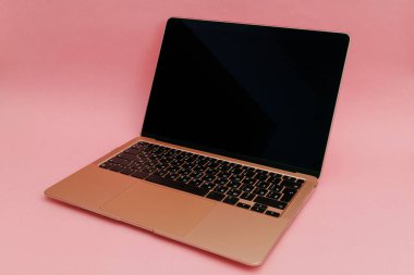Pembe arka planda altın bir laptop