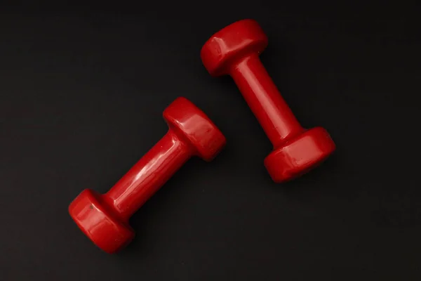 stock image Little red weights on a black background