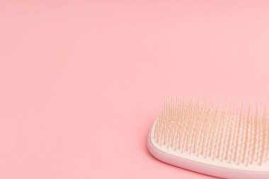 Pembe arka planlı plastik saç fırçası