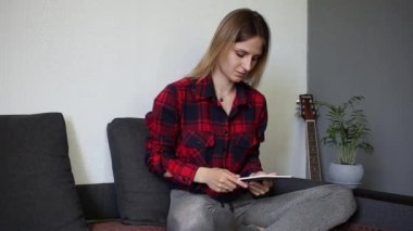 Bir kadın tablete bakar ve güler.