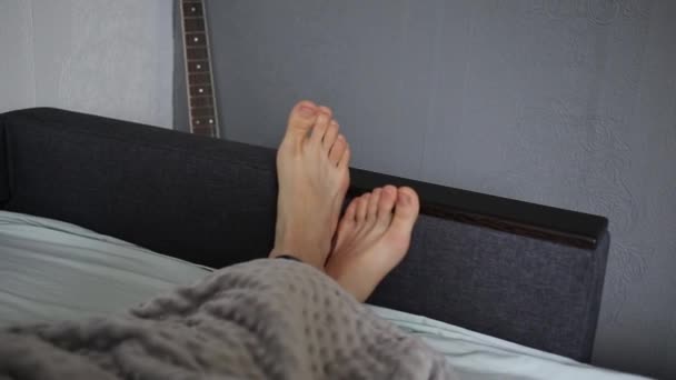 Man Bed Wiggles His Legs — Stock Video