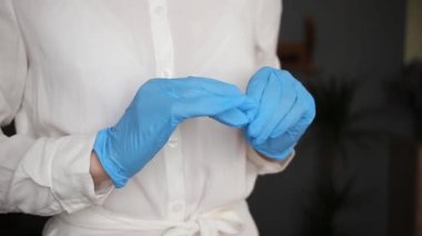 Hemşire eldivenlerini çıkarır, hızlı hareket eder.