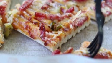 Sosisli ve peynirli sulu bir dilim pizza, yavaşlatılmış.