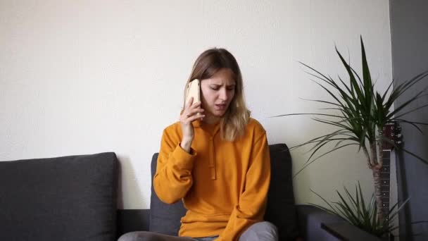 Ένα Δυσαρεστημένο Κορίτσι Μιλάει Στο Τηλέφωνο Και Αγανακτεί — Αρχείο Βίντεο
