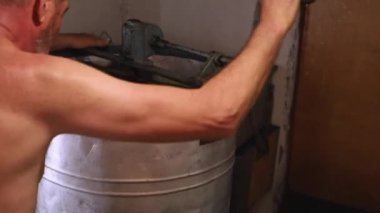 Bir adam bal tüpüne bal pompalıyor.