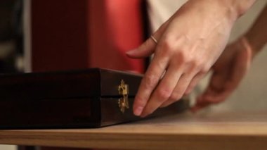 Bir kız tahta bir kutuyu masa oyunuyla açıyor.